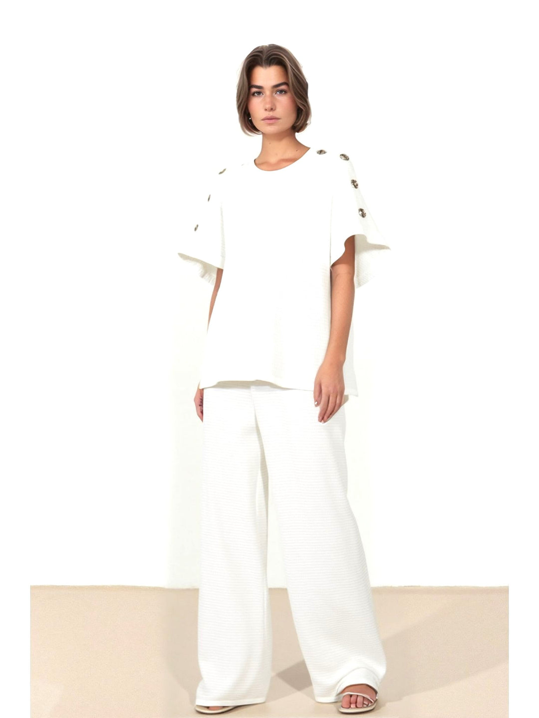 Woman wearing a white outfit with gold accents on a white background